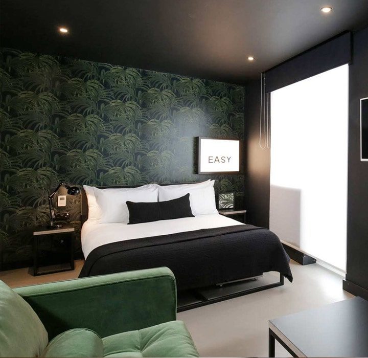 Dark green and black themed modern hotel room