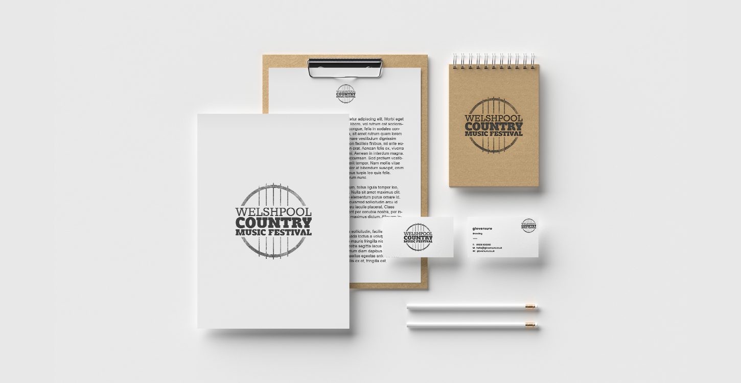 Festival branding for Welshpool country music festival, shown on a notepad, business cards and documents on a white background