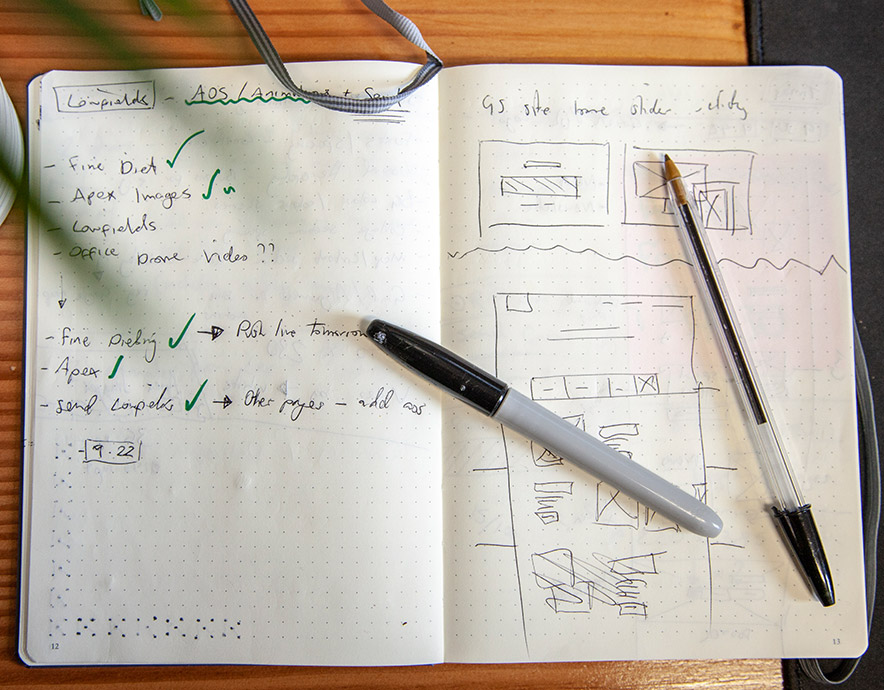 Website Design sketch on a notepad with two pens on top