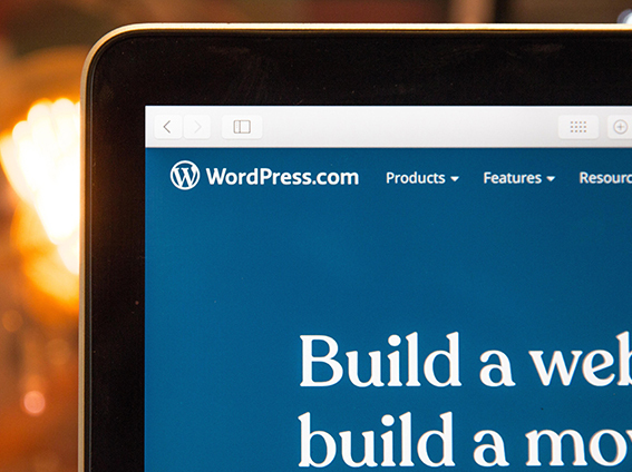 The corner of a laptop screen showing the wordpress website open 