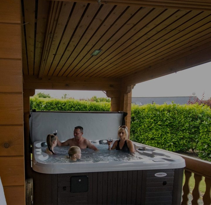 Family of four enjoying some hot-tub time in a luxury lodge