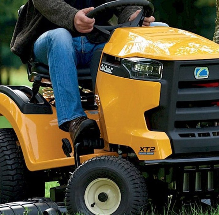 Man in blue jeans driving a yellow Cub Cadet XZ2 mower