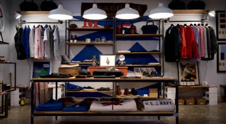 Inside a local fashion shop, showing shelves of navy, white and grey clothing