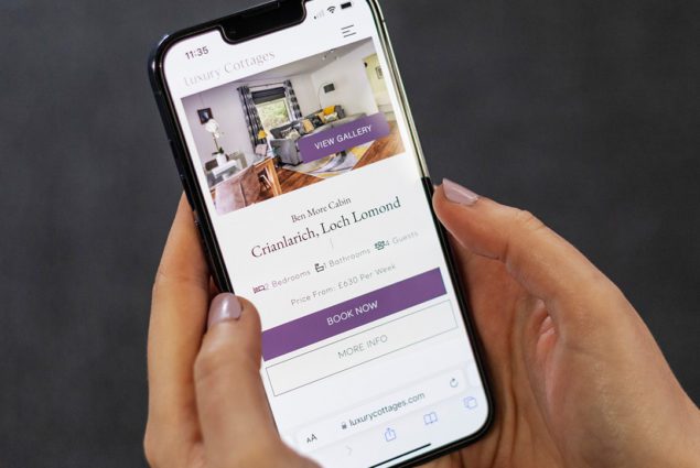 luxury holiday home web design displayed on an iPhone in a womens hand
